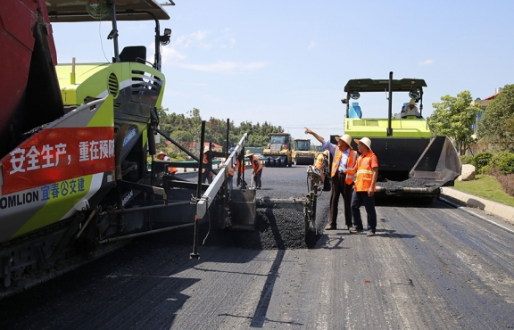 攤鋪機(jī)、壓路機(jī)等設(shè)備緊張有序運(yùn)行，高達(dá)170℃的瀝青混合料炙烤著公路人